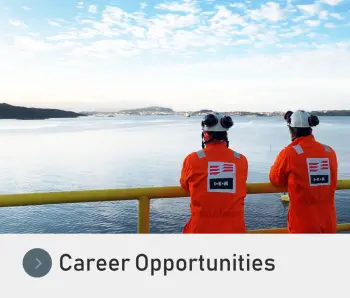 Two IKM Testing UK Employees standing on an oil rig looking at the ocean with a Career Opportunities button underneath